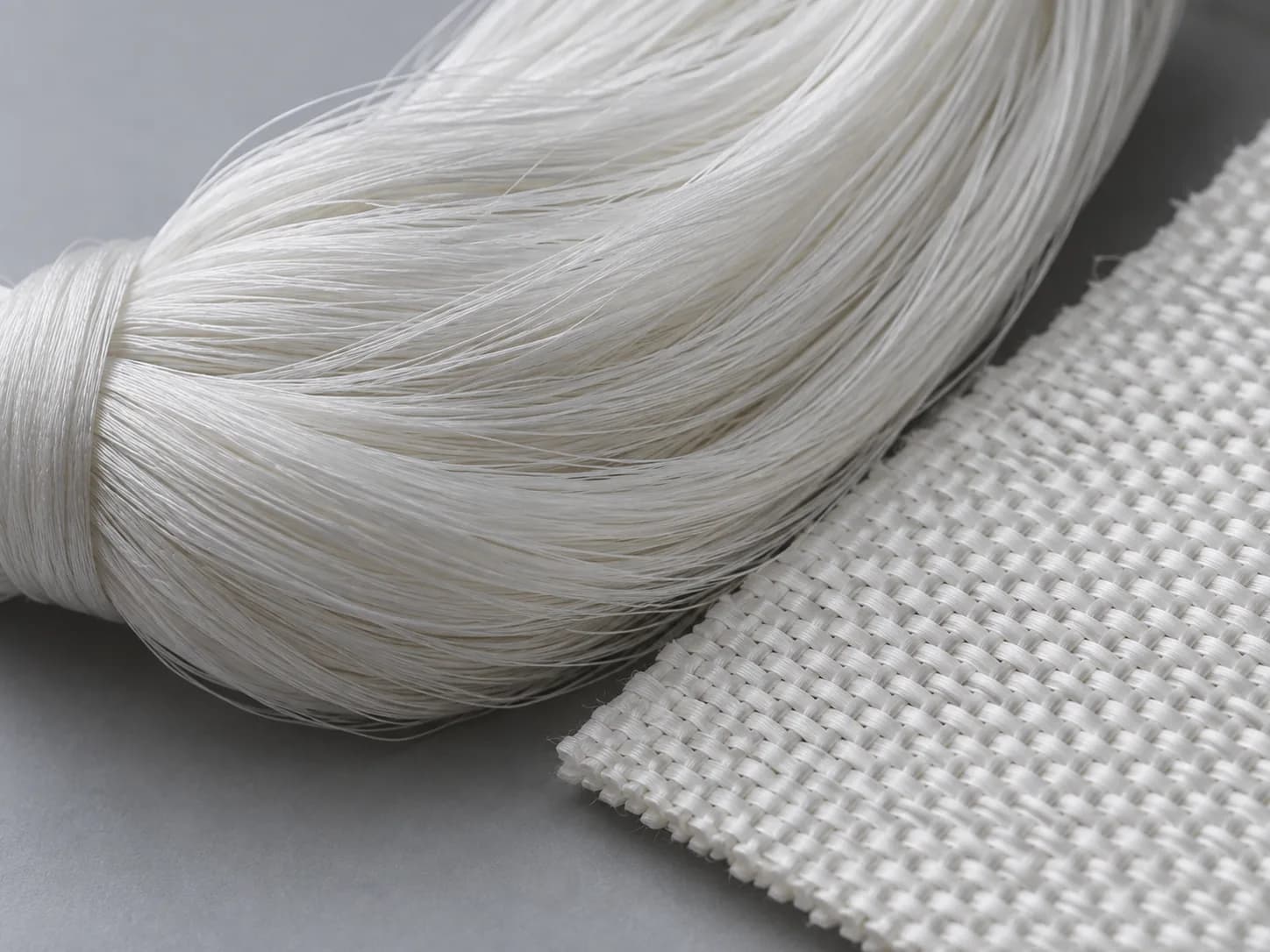Material concept of fine white UHMWPE filaments and a compact woven direction